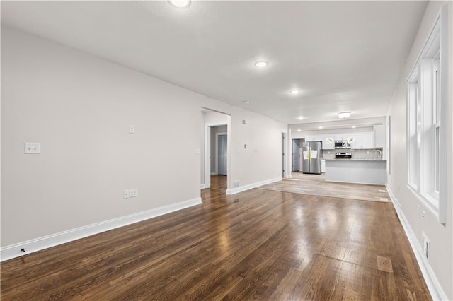 3107 N 34th St, Kansas City, KS 66104 - unfurnished living room with wood finished floors, baseboards, recessed lighting, and a sink