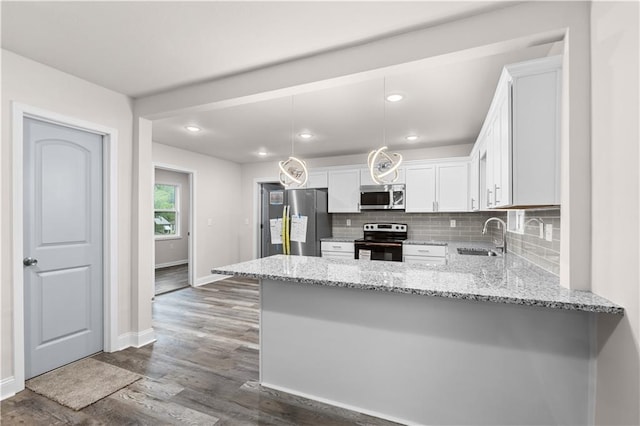 3107 N 34th St, Kansas City, KS 66104 - kitchen with appliances with stainless steel finishes, a sink, a peninsula, white cabinets, and light stone countertops