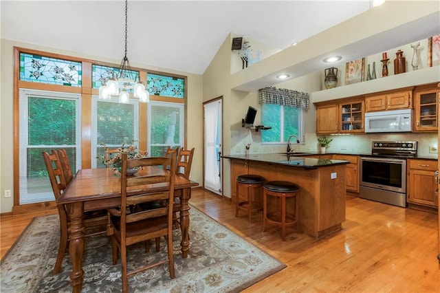 5162 Roundtree St, Shawnee, KS 66226 - dining space with a chandelier, light wood-style floors, and high vaulted ceiling