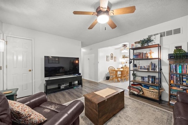 808 SE 19th St, Oak Grove, MO 64075 - living room with ceiling fan, wood finished floors, a textured ceiling, and baseboards