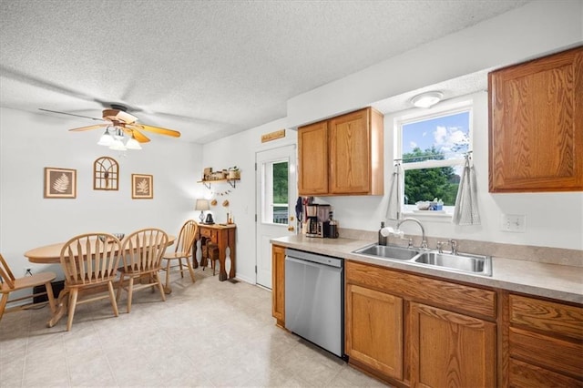 808 SE 19th St, Oak Grove, MO 64075 - kitchen with stainless steel dishwasher, a sink, a textured ceiling, brown cabinets, and light countertops