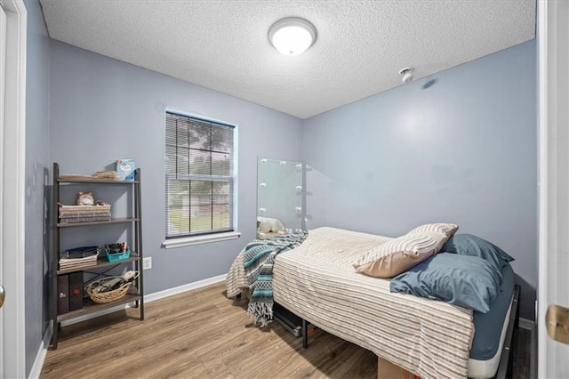 808 SE 19th St, Oak Grove, MO 64075 - bedroom featuring wood finished floors, a textured ceiling, and baseboards