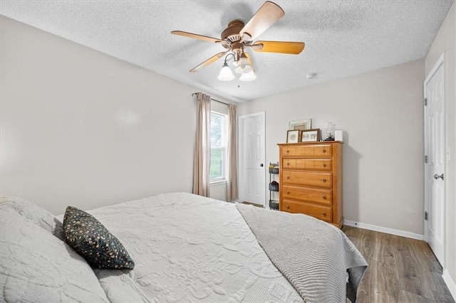 808 SE 19th St, Oak Grove, MO 64075 - bedroom featuring wood finished floors, a textured ceiling, baseboards, and ceiling fan