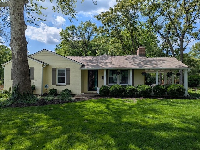 ranch-style house featuring a chimney, a front yard, and a porch