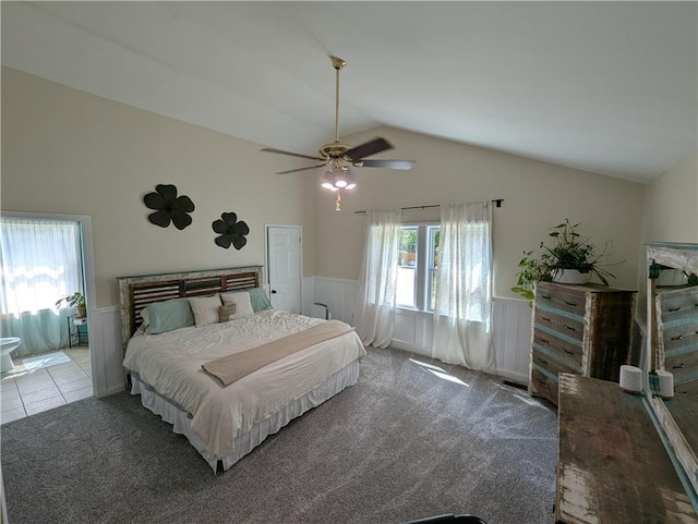 bedroom with wainscoting, lofted ceiling, carpet flooring, and a ceiling fan