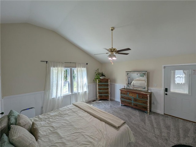 carpeted bedroom featuring a wainscoted wall, vaulted ceiling, and ceiling fan