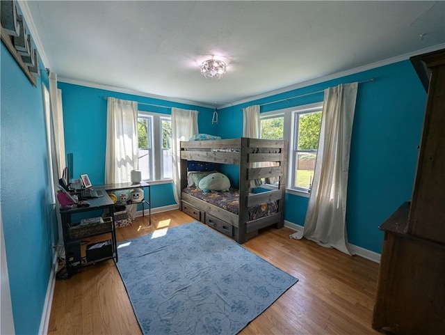 bedroom with baseboards, multiple windows, and crown molding