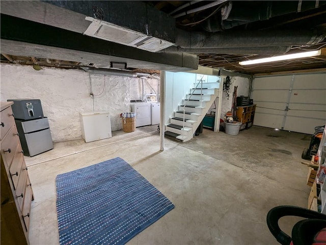 unfinished basement featuring washer and dryer, fridge, and stairway