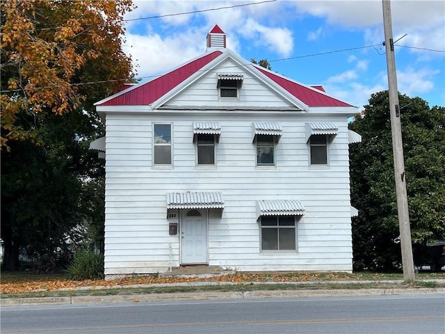 view of front of property with metal roof and a chimney