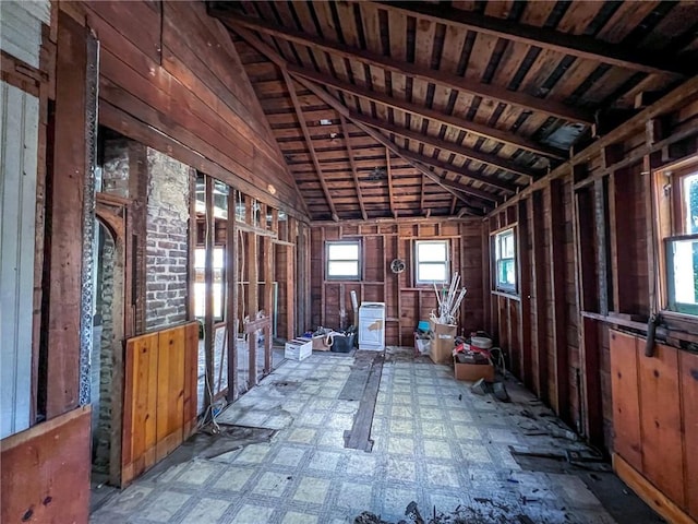 miscellaneous room with lofted ceiling, tile patterned floors, and wood walls