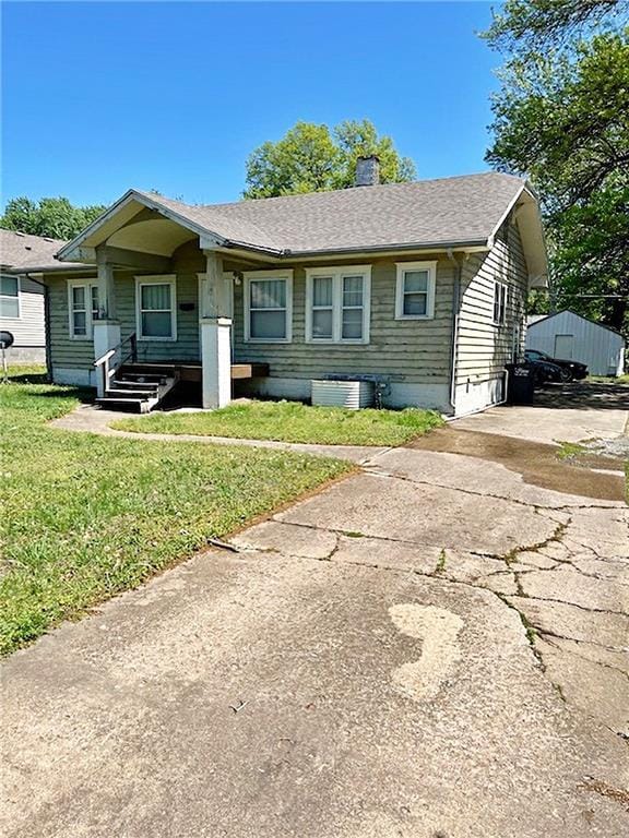 2011 S Broadway St, Pittsburg, KS 66762 - view of front of home with a chimney, a front yard, central AC unit, and roof with shingles