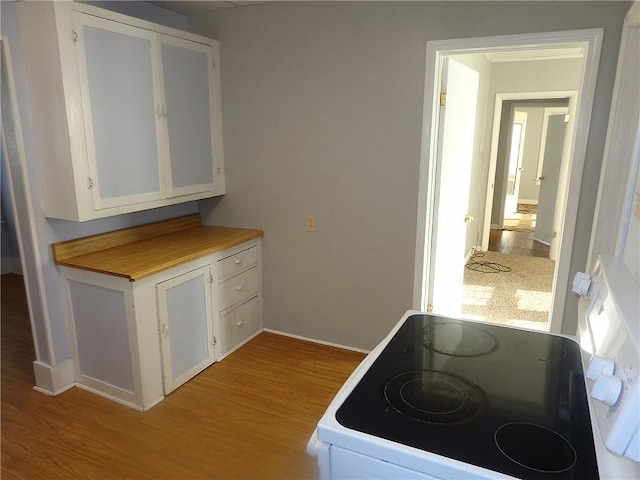 2011 S Broadway St, Pittsburg, KS 66762 - kitchen with white electric range, light wood-type flooring, white cabinets, and baseboards