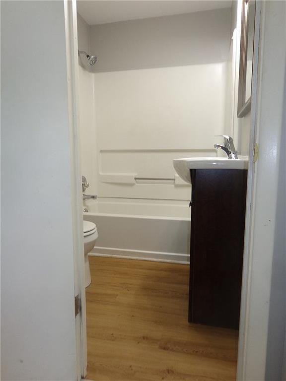 2011 S Broadway St, Pittsburg, KS 66762 - full bath featuring vanity, wood finished floors, toilet, and shower / washtub combination