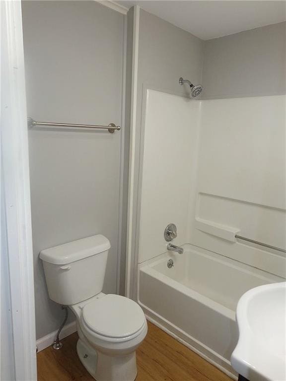 2011 S Broadway St, Pittsburg, KS 66762 - bathroom with wood finished floors, washtub / shower combination, and toilet