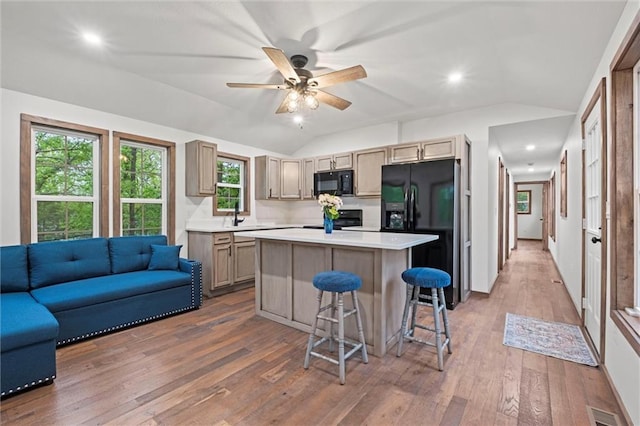 13 S Lakeside Cir, Linn Valley, KS 66040 - kitchen with black appliances, lofted ceiling, light countertops, a kitchen island, and hardwood / wood-style flooring