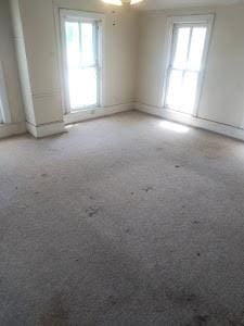 unfurnished room with baseboards
