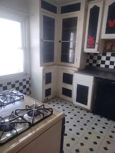 kitchen featuring gas range and tasteful backsplash