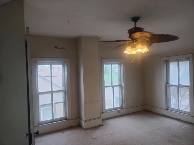 spare room with a ceiling fan and light carpet