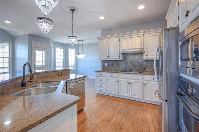 kitchen featuring a sink, appliances with stainless steel finishes, white cabinets, light wood-style floors, and recessed lighting
