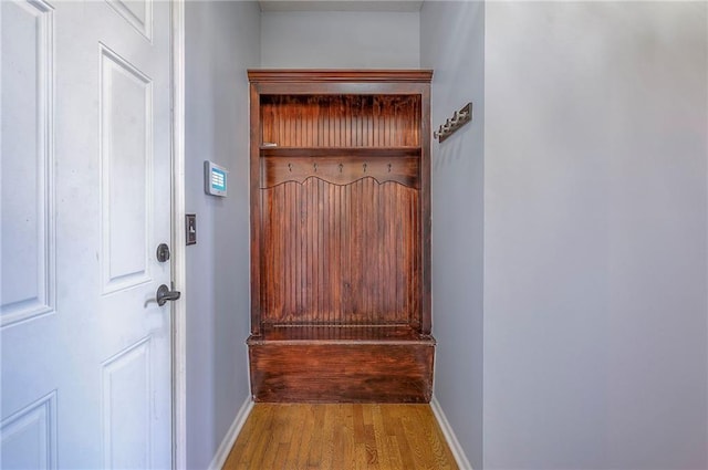 doorway featuring wood finished floors and baseboards