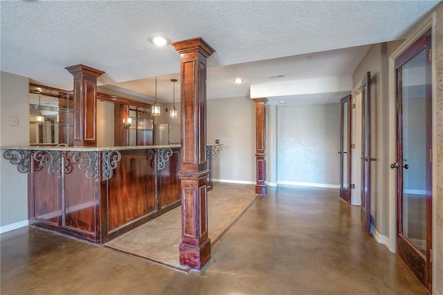 bar area with ornate columns, finished concrete flooring, baseboards, a textured ceiling, and recessed lighting