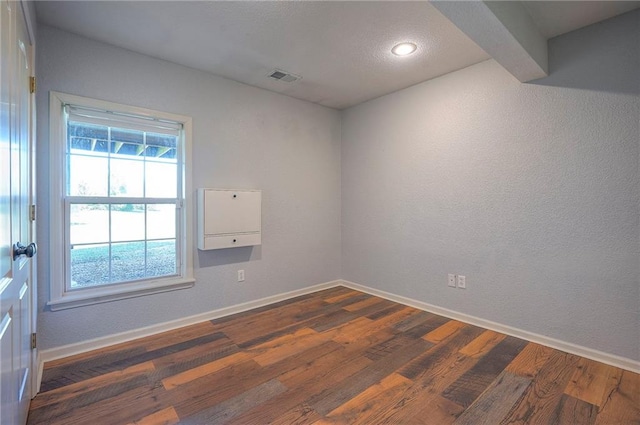 spare room with dark wood finished floors, baseboards, and recessed lighting