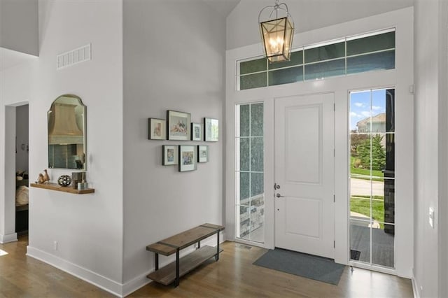 10523 N Dalton Ave, Kansas City, MO 64154 - foyer entrance with a towering ceiling, wood finished floors, baseboards, and a chandelier