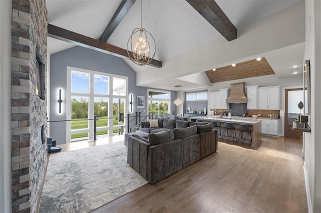 10523 N Dalton Ave, Kansas City, MO 64154 - living room featuring a chandelier, beam ceiling, light wood finished floors, and high vaulted ceiling