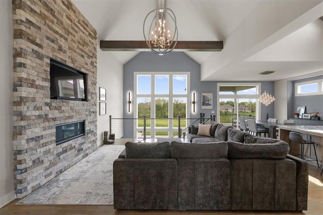 10523 N Dalton Ave, Kansas City, MO 64154 - living area featuring a chandelier, wood finished floors, a stone fireplace, and high vaulted ceiling
