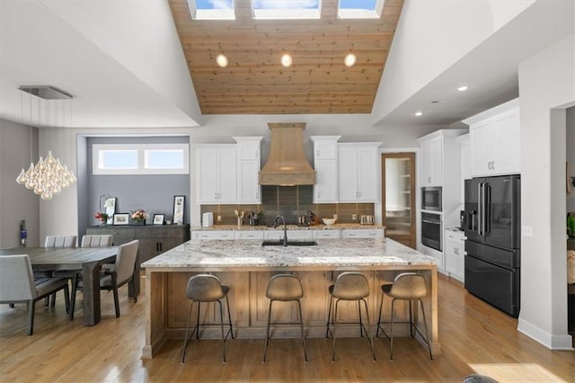 10523 N Dalton Ave, Kansas City, MO 64154 - kitchen featuring appliances with stainless steel finishes, premium range hood, a sink, white cabinets, and high vaulted ceiling