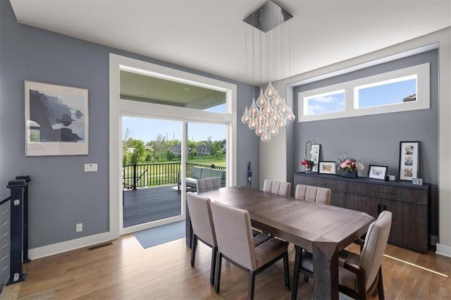 10523 N Dalton Ave, Kansas City, MO 64154 - dining room featuring wood finished floors, baseboards, and a chandelier