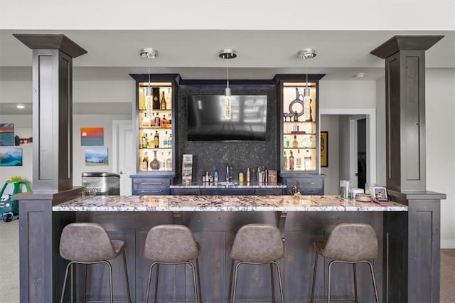 10523 N Dalton Ave, Kansas City, MO 64154 - indoor wet bar with carpet flooring, decorative columns, and pendant lighting