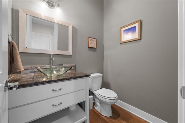 10523 N Dalton Ave, Kansas City, MO 64154 - bathroom with wood finished floors, toilet, vanity, and baseboards