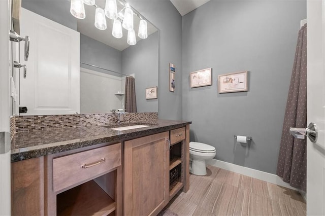 10523 N Dalton Ave, Kansas City, MO 64154 - bathroom featuring toilet, vanity, baseboards, and a shower with shower curtain