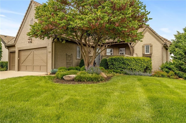 15201 Catalina St, Leawood, KS 66224 - obstructed view of property featuring stucco siding, concrete driveway, a front lawn, and a garage