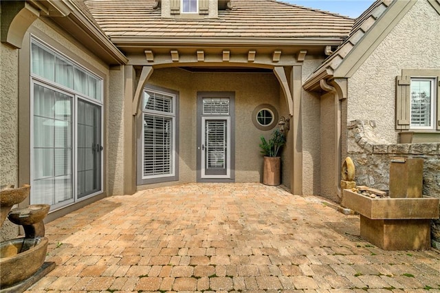 15201 Catalina St, Leawood, KS 66224 - entrance to property with stucco siding, a patio area, and a tiled roof