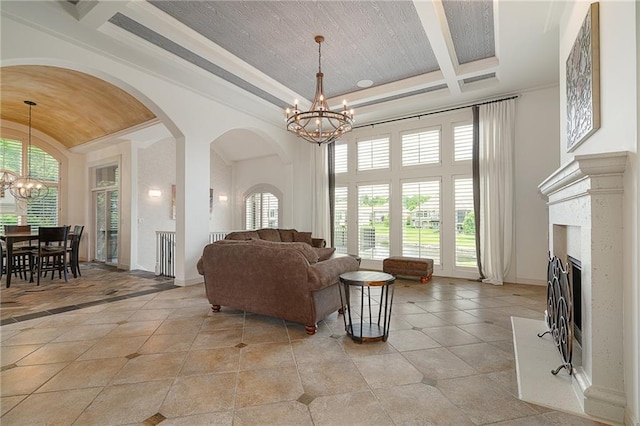 15201 Catalina St, Leawood, KS 66224 - living area featuring a chandelier, a fireplace, light tile patterned floors, arched walkways, and a towering ceiling