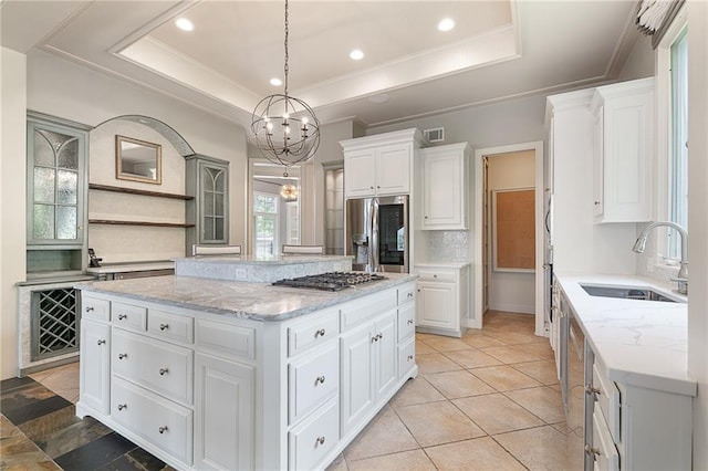 15201 Catalina St, Leawood, KS 66224 - kitchen with appliances with stainless steel finishes, a sink, a tray ceiling, a kitchen island, and ornamental molding