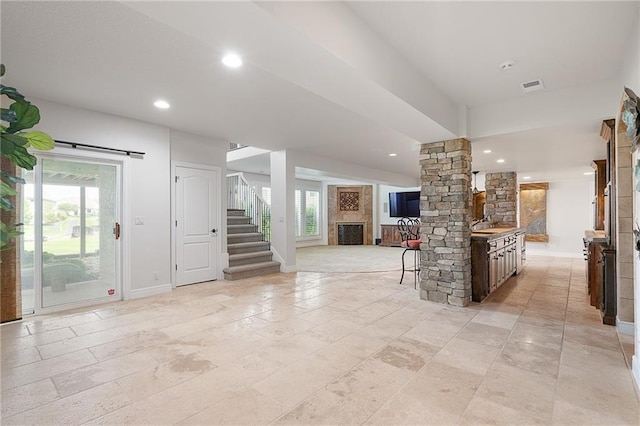 15201 Catalina St, Leawood, KS 66224 - living room with a fireplace, ornate columns, baseboards, stairs, and recessed lighting