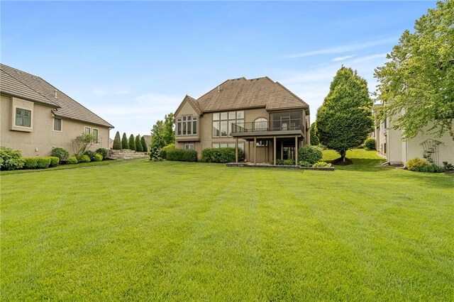 15201 Catalina St, Leawood, KS 66224 - rear view of house featuring a lawn, stucco siding, and a balcony