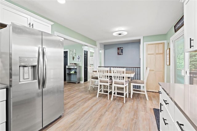 201 N Cleveland Ave, Belton, MO 64012 - kitchen featuring stainless steel fridge, light wood-type flooring, and white cabinetry