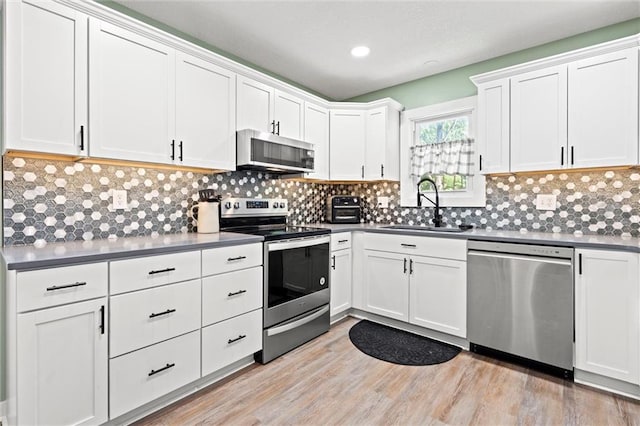 201 N Cleveland Ave, Belton, MO 64012 - kitchen featuring appliances with stainless steel finishes, a sink, white cabinets, backsplash, and recessed lighting