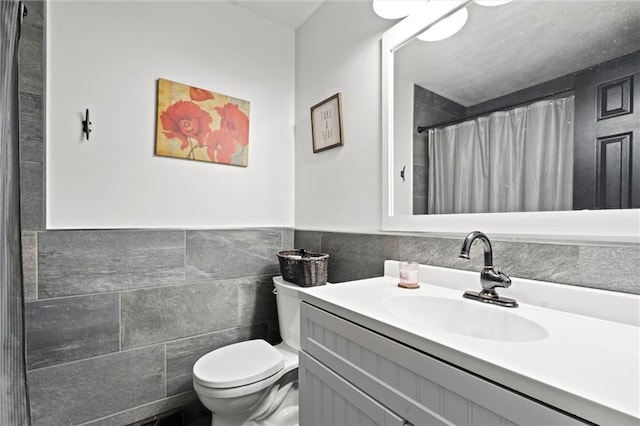 201 N Cleveland Ave, Belton, MO 64012 - bathroom featuring toilet, vanity, tile walls, and a shower with shower curtain