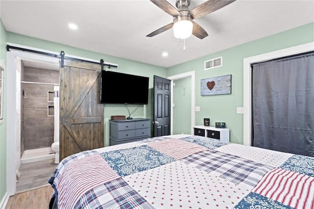 201 N Cleveland Ave, Belton, MO 64012 - bedroom featuring a barn door, wood finished floors, recessed lighting, and ceiling fan