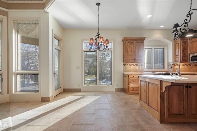 4704 W 152nd St, Leawood, KS 66224 - kitchen with stainless steel microwave, a chandelier, backsplash, healthy amount of natural light, and recessed lighting