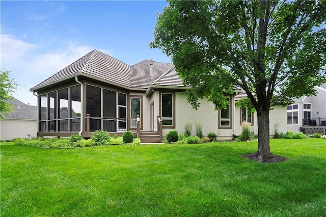 4704 W 152nd St, Leawood, KS 66224 - back of house featuring a sunroom, a lawn, and stucco siding