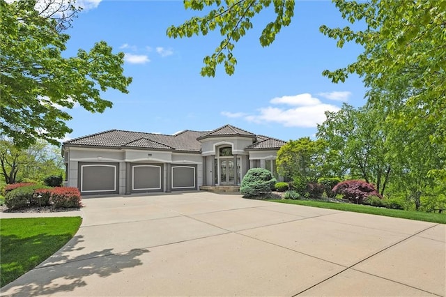 21211 E 34th St S, Independence, MO 64057 - mediterranean / spanish home with an attached garage, concrete driveway, stucco siding, and a tiled roof