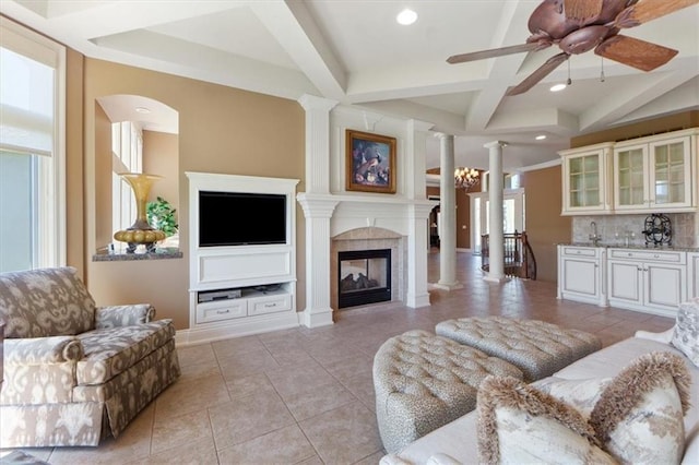 21211 E 34th St S, Independence, MO 64057 - living area with ornate columns, beamed ceiling, ceiling fan, a glass covered fireplace, and light tile patterned floors