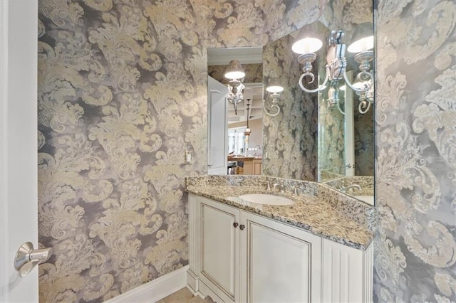 21211 E 34th St S, Independence, MO 64057 - bathroom with baseboards, wallpapered walls, and vanity