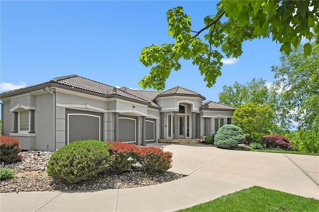 21211 E 34th St S, Independence, MO 64057 - mediterranean / spanish-style house featuring an attached garage, stucco siding, concrete driveway, and a tile roof